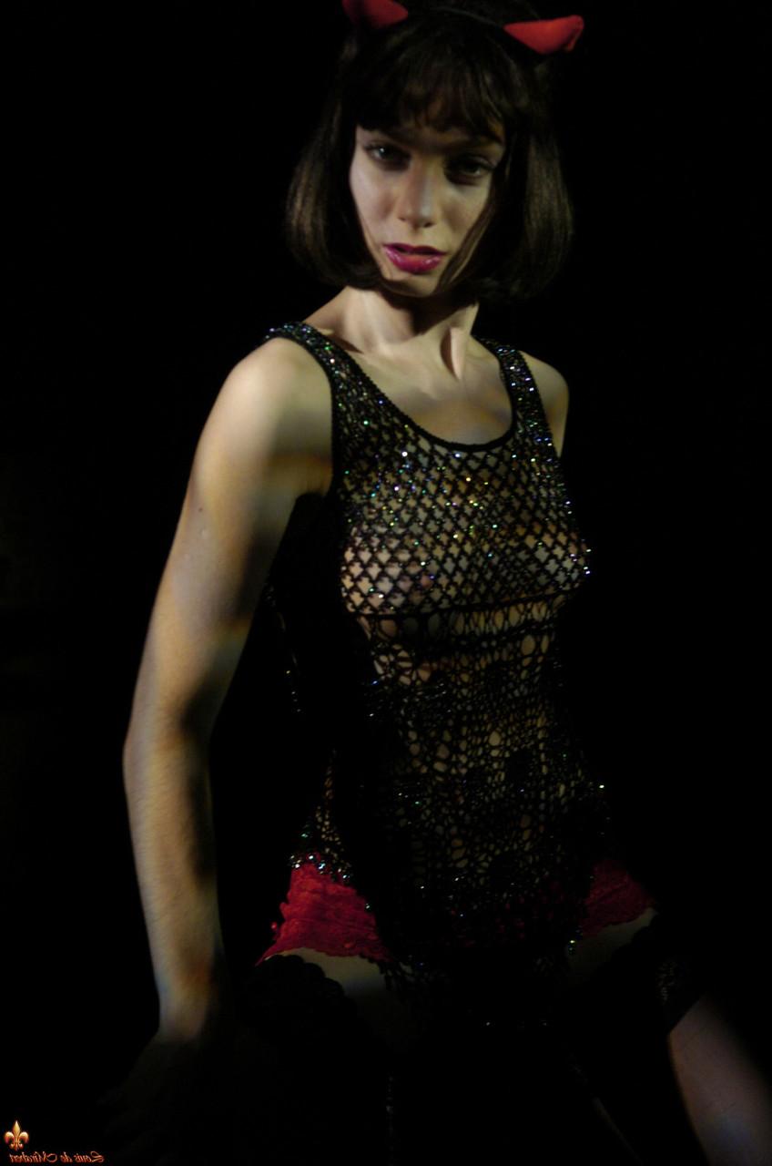 16P La brune sexy Eleonore arbore des cornes de diable tout en montrant ses seins et sa chatte.