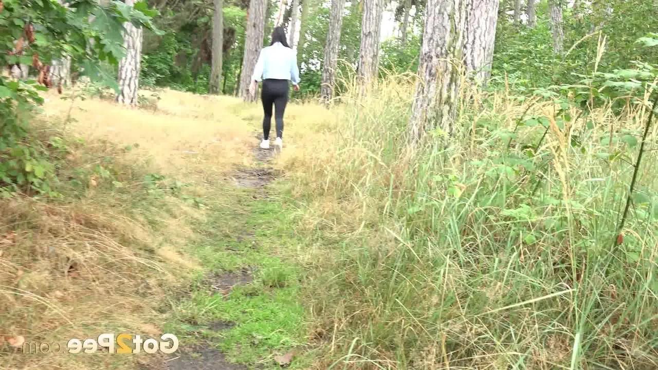 15P Das brünette Mädchen Dafne zieht ihre schwarzen Leggings herunter, um dringend im Wald zu pinkeln