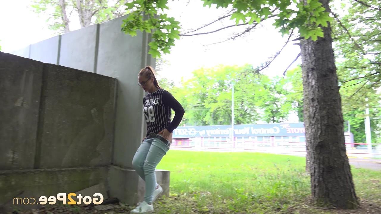 15P Caucasian girl Naomi Bennet ducks behind a concrete wall for a much needed pee