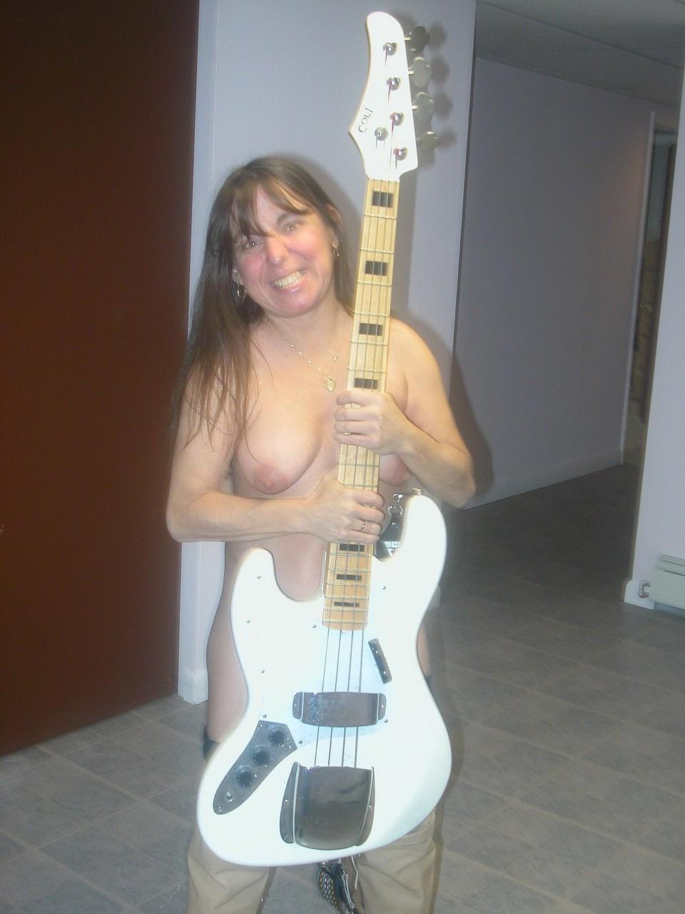 20P Naughty MILF Vixen strips down to her stockings while playing her guitar