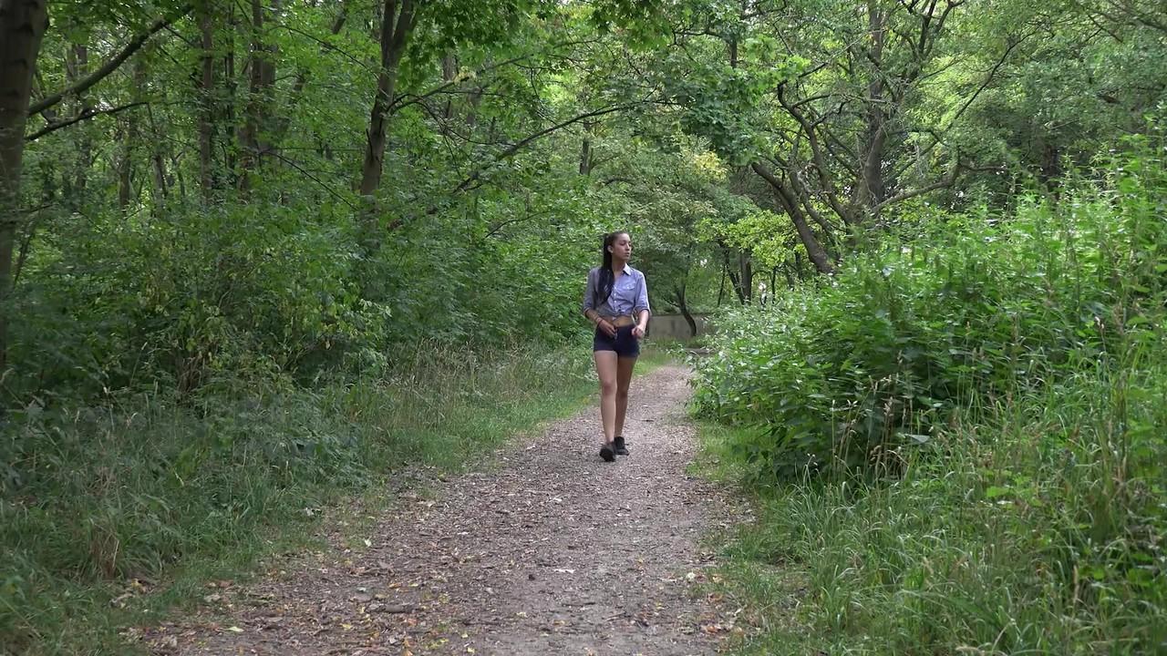 15P A garota de cabelos escuros Amanda Estela faz xixi muito necessário em um caminho na floresta