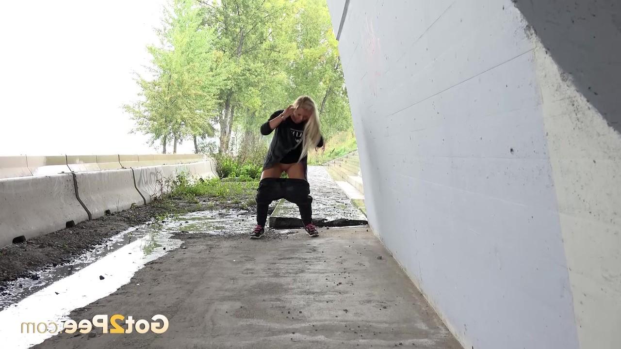 15P La blonde Jenna Lovely baisse son pantalon pour faire pipi sur un morceau de béton.