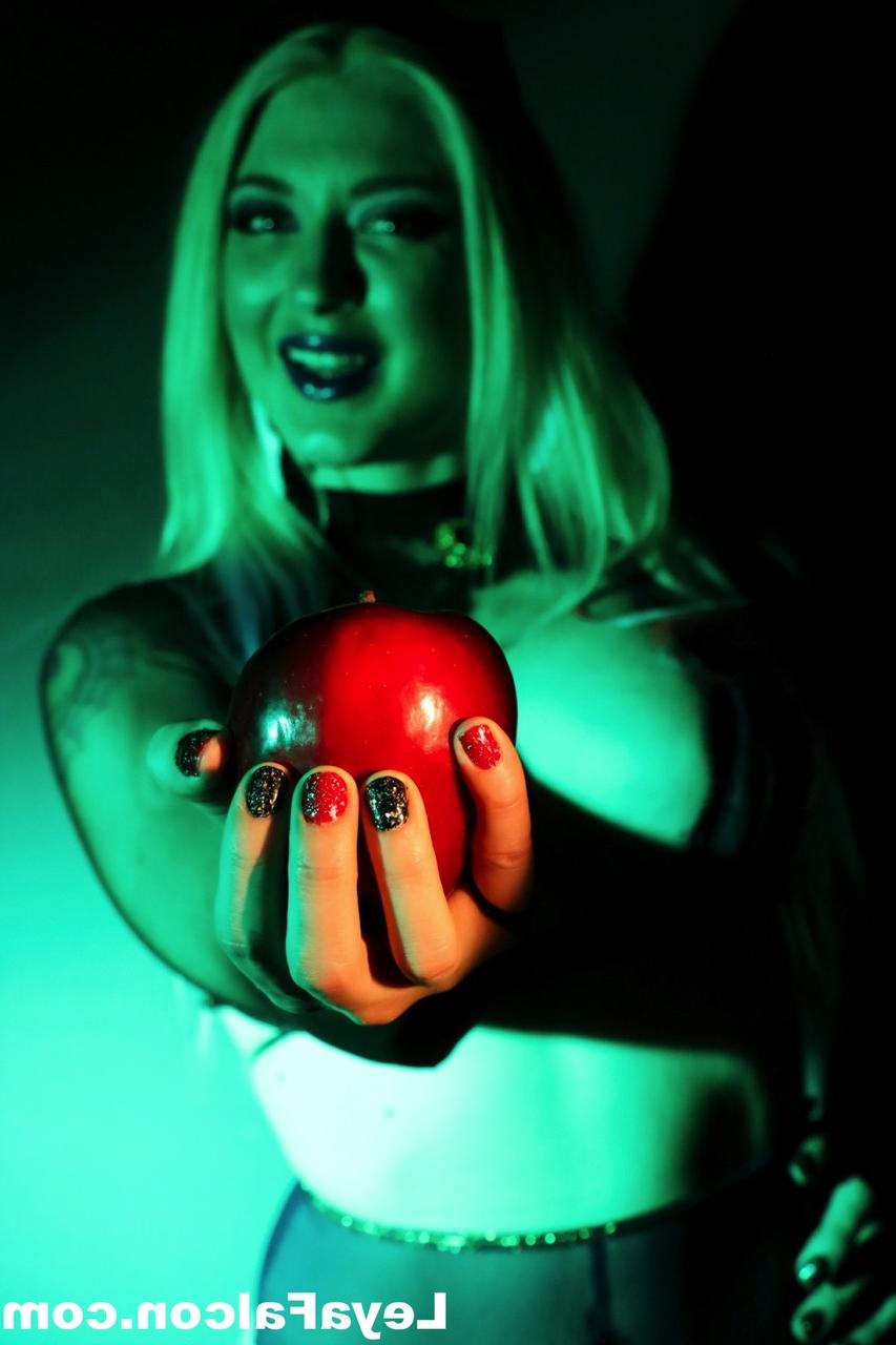 12P Blonde MILF Leya Falcon holds an apple while wearing sheer lingerie