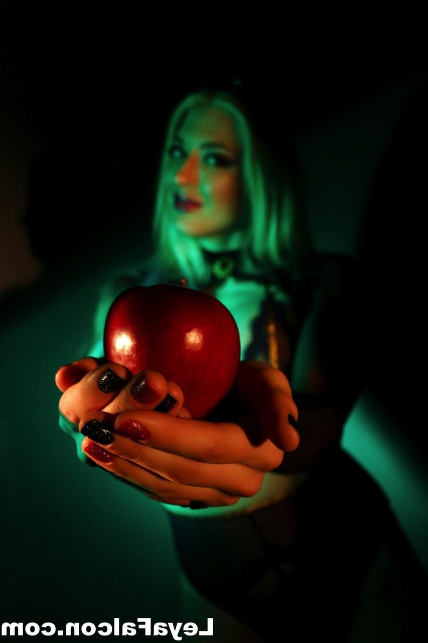 12P Blonde MILF Leya Falcon holds an apple while wearing sheer lingerie