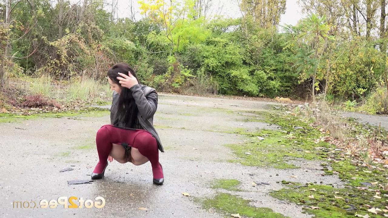 15P Corin pulls down her tights before pissing on a patch of wet pavement