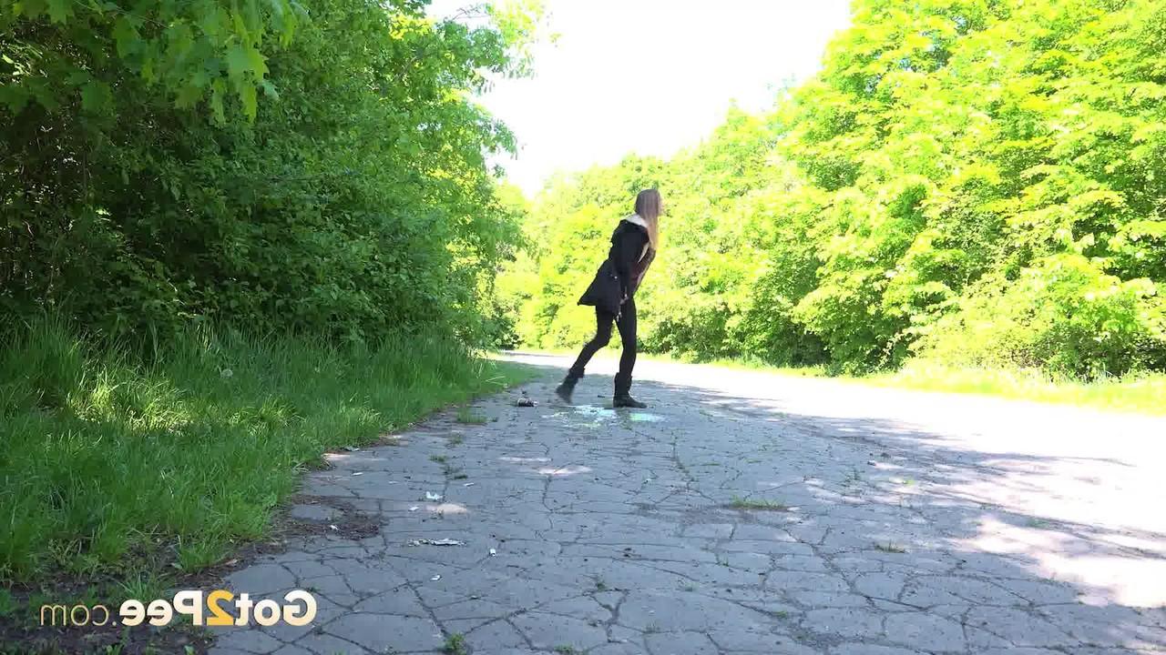 15P Caucasian female Cynthia Vellons takes a piss on a paved road in suede boots