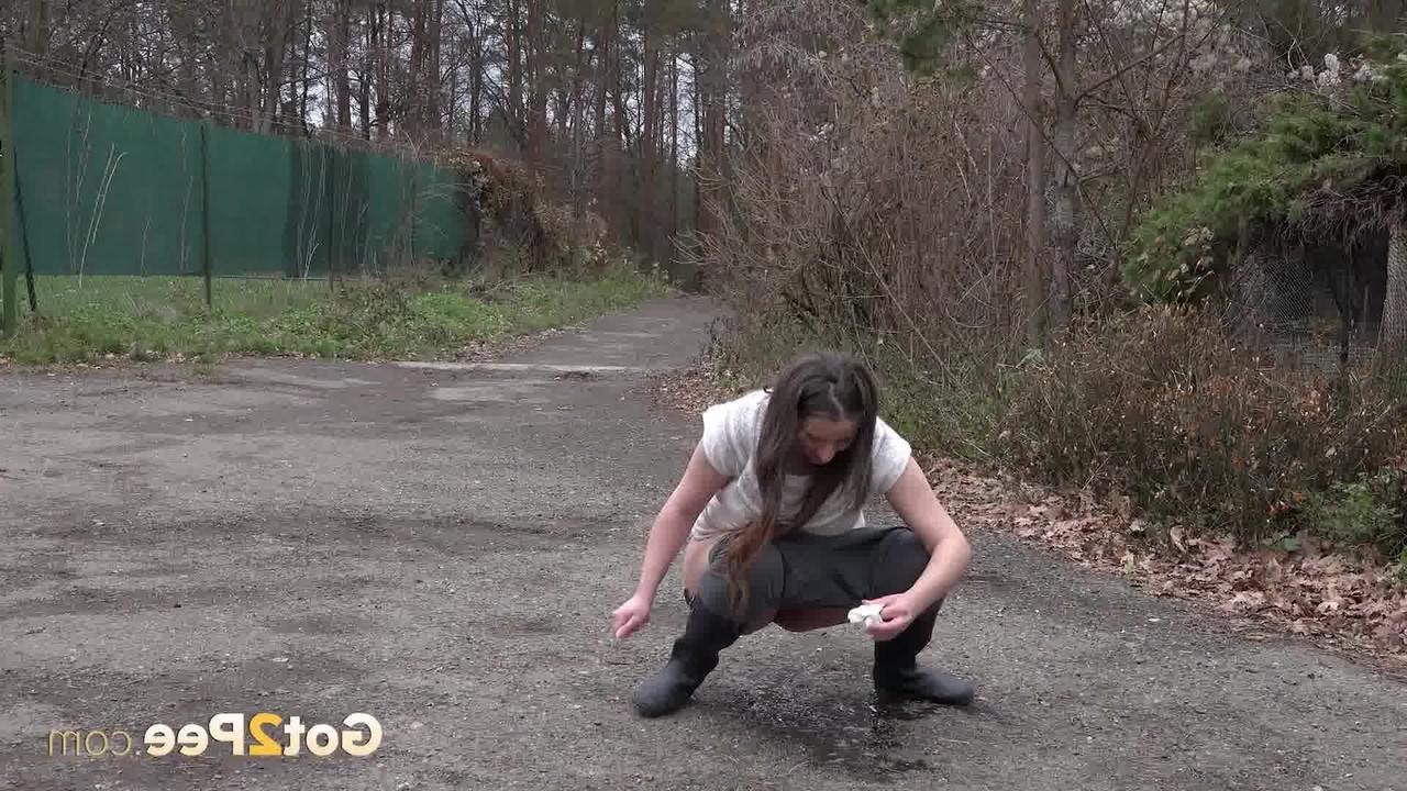 15P Nicolette Noir, une adolescente courte, fait pipi sur une route tout en portant des bottes en caoutchouc.