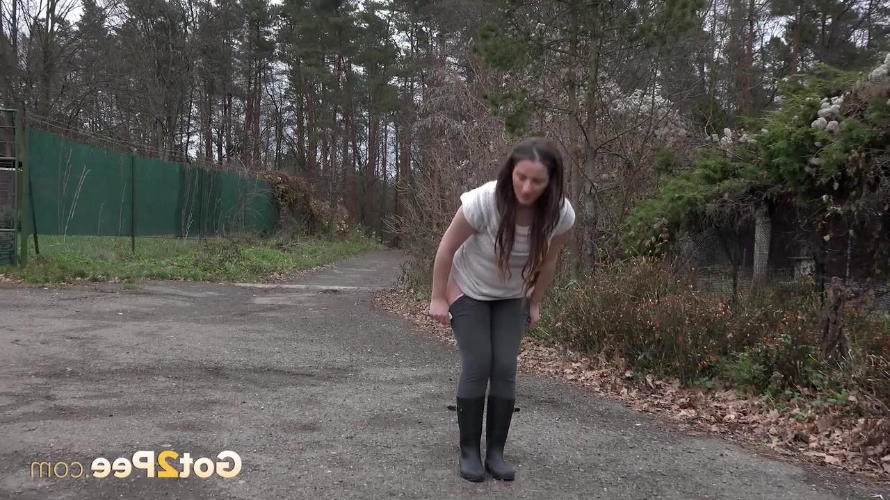 15P Nicolette Noir, une adolescente courte, fait pipi sur une route tout en portant des bottes en caoutchouc.