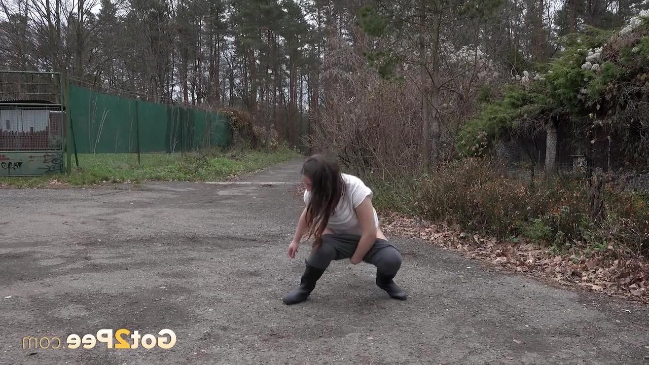 15P Nicolette Noir, une adolescente courte, fait pipi sur une route tout en portant des bottes en caoutchouc.