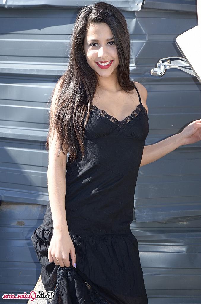 12P Die dunkelhaarige Amateurin Bella Quinn modelt draußen auf einem Schrottplatz in einem schwarzen Kleid