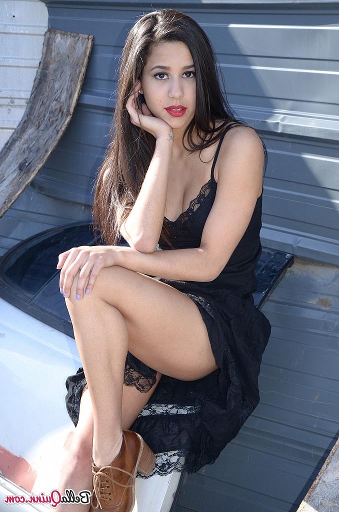 12P Die dunkelhaarige Amateurin Bella Quinn modelt draußen auf einem Schrottplatz in einem schwarzen Kleid