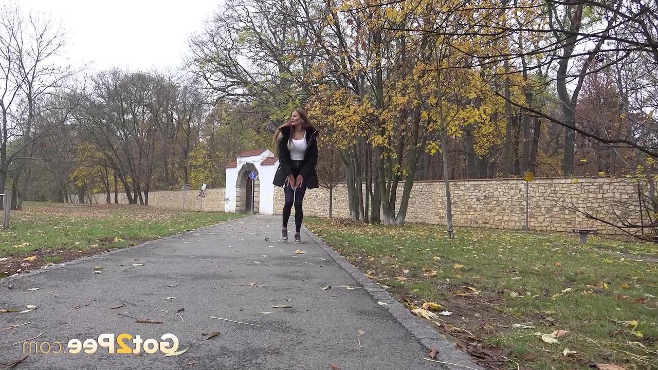 15P A garota caucasiana Maddi Black mija contra uma árvore em um parque