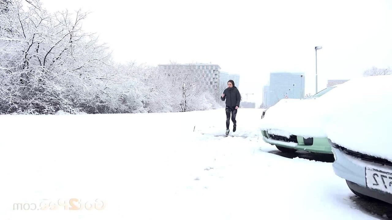 15P ララ・フォックスは駐車した車の近くの雪に覆われた地面で緊急小便をする