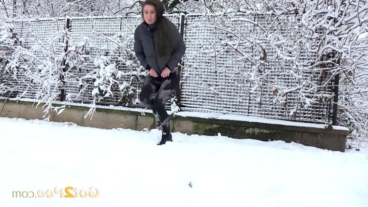 15P ララ・フォックスは駐車した車の近くの雪に覆われた地面で緊急小便をする
