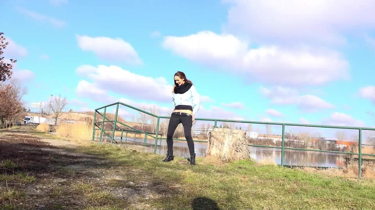 15P La nana blanche Cynthia Vellons baisse son pantalon noir pour faire pipi près d'un chemin de gravier.