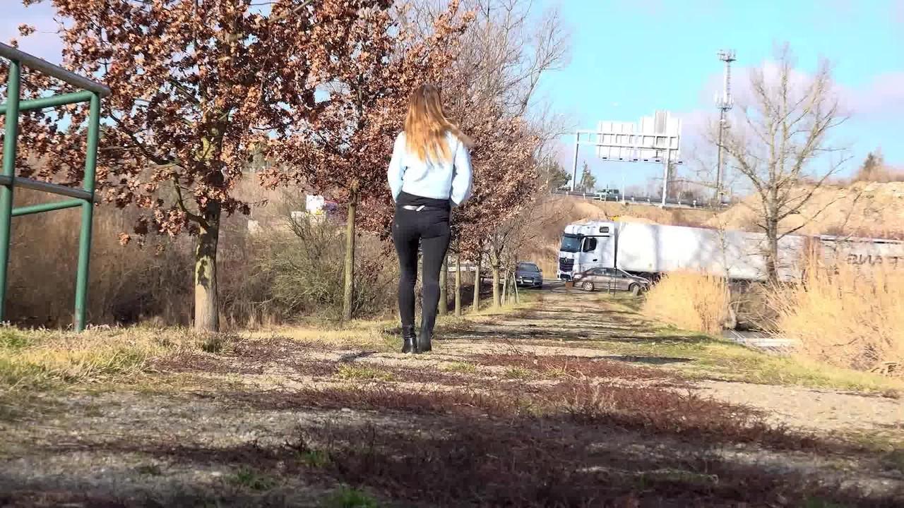 15P La nana blanche Cynthia Vellons baisse son pantalon noir pour faire pipi près d'un chemin de gravier.