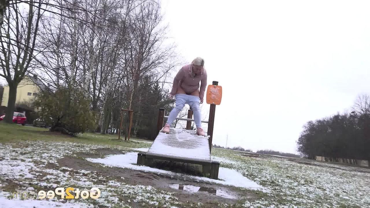 15P A loira Licky Lex faz xixi em um escorregador coberto de neve em um parque