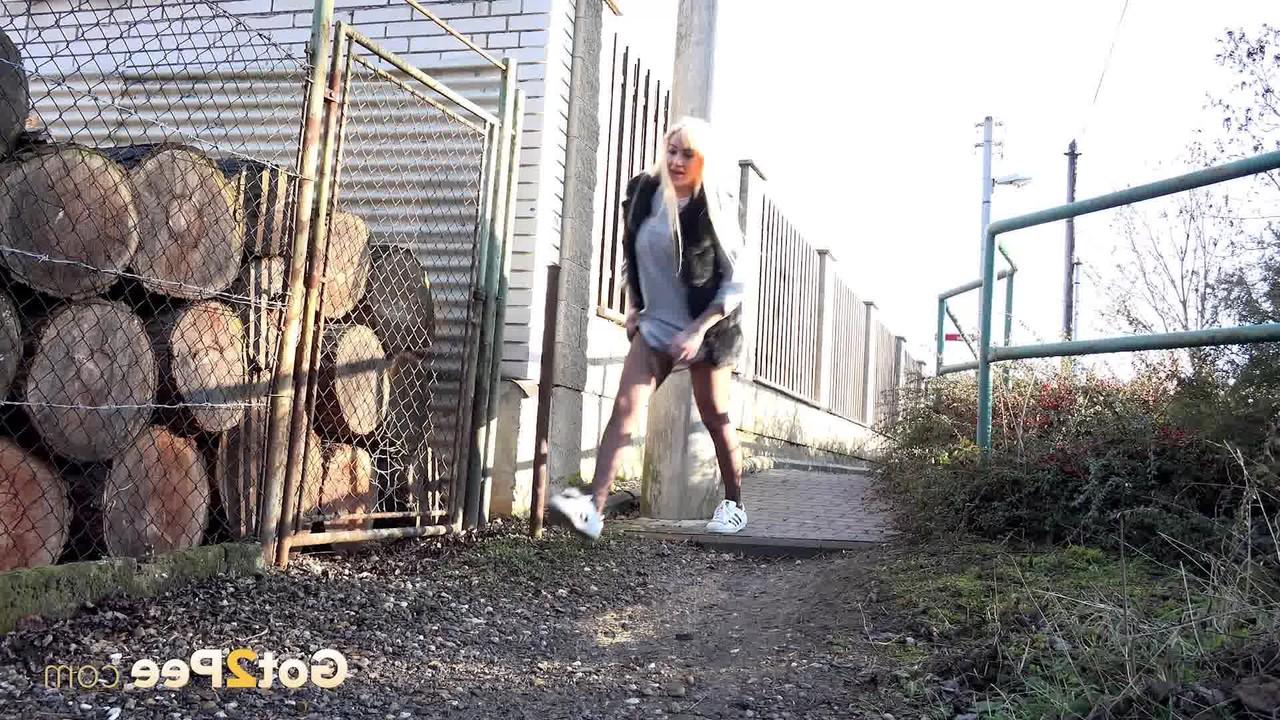 15P La blonde Daisy Lee s'accroupit pour pisser dans une ruelle.