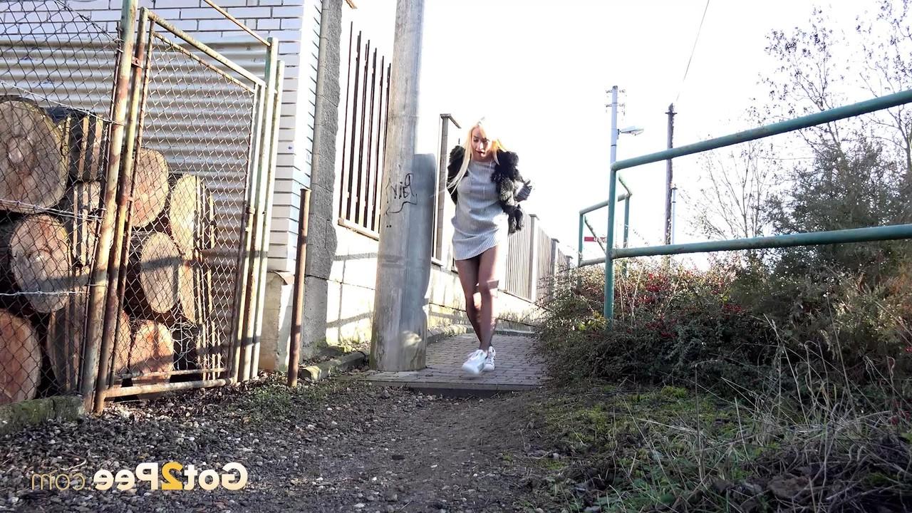 15P La blonde Daisy Lee s'accroupit pour pisser dans une ruelle.