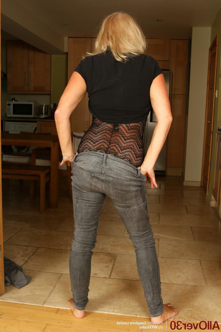 20P La blonde mature Sapphire Louise enlève ses bottes et écarte la chatte.