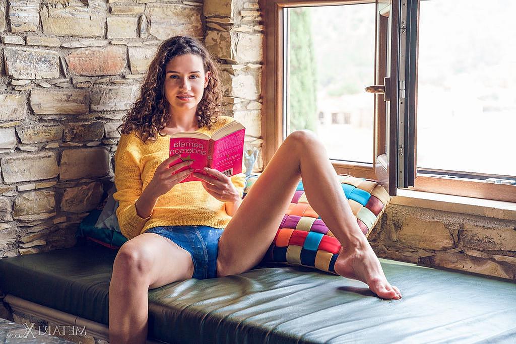 15P A jovem magra Cristin fica totalmente nua enquanto lê um livro perto de uma janela