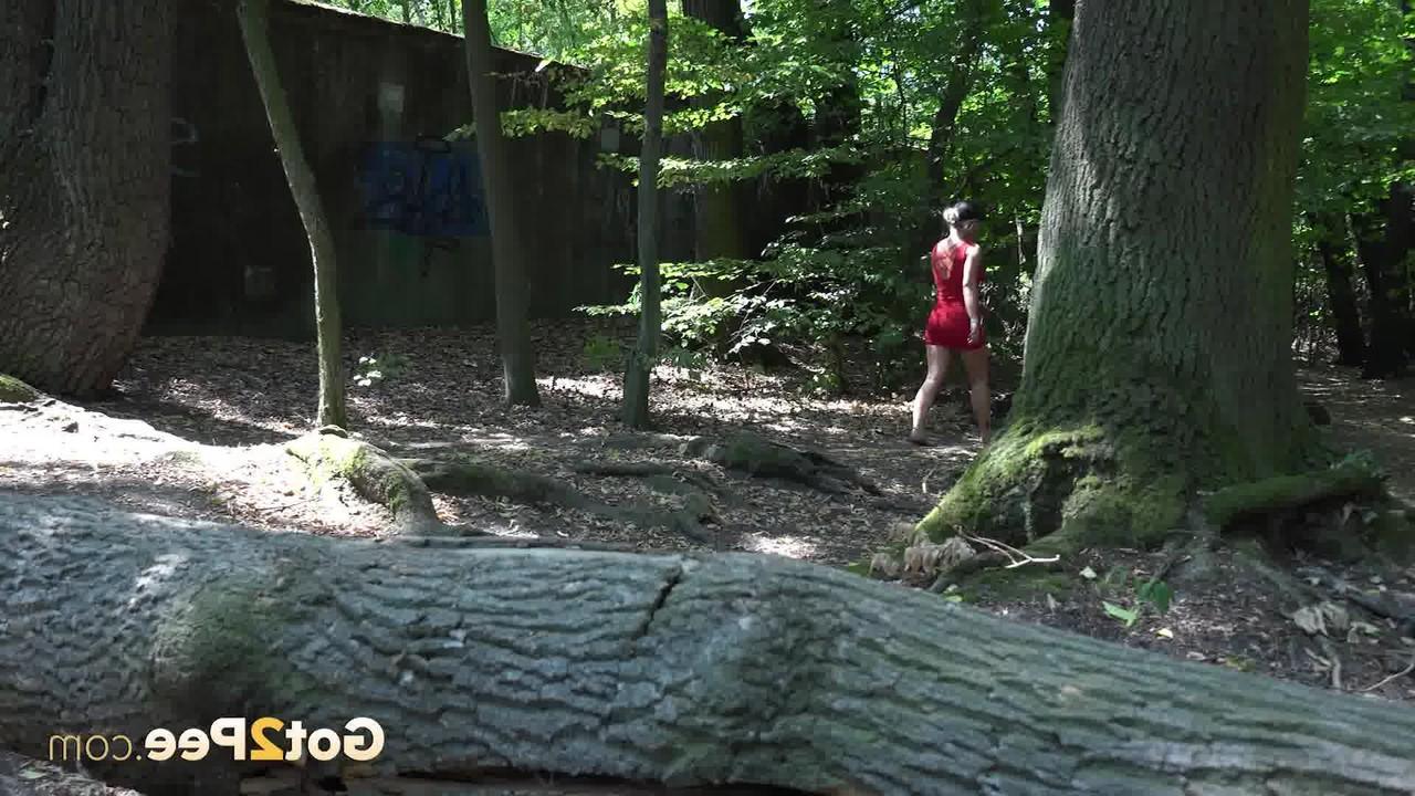 15P Das blonde Mädchen Licky Lex pinkelt im Wald über einen umgestürzten Baum