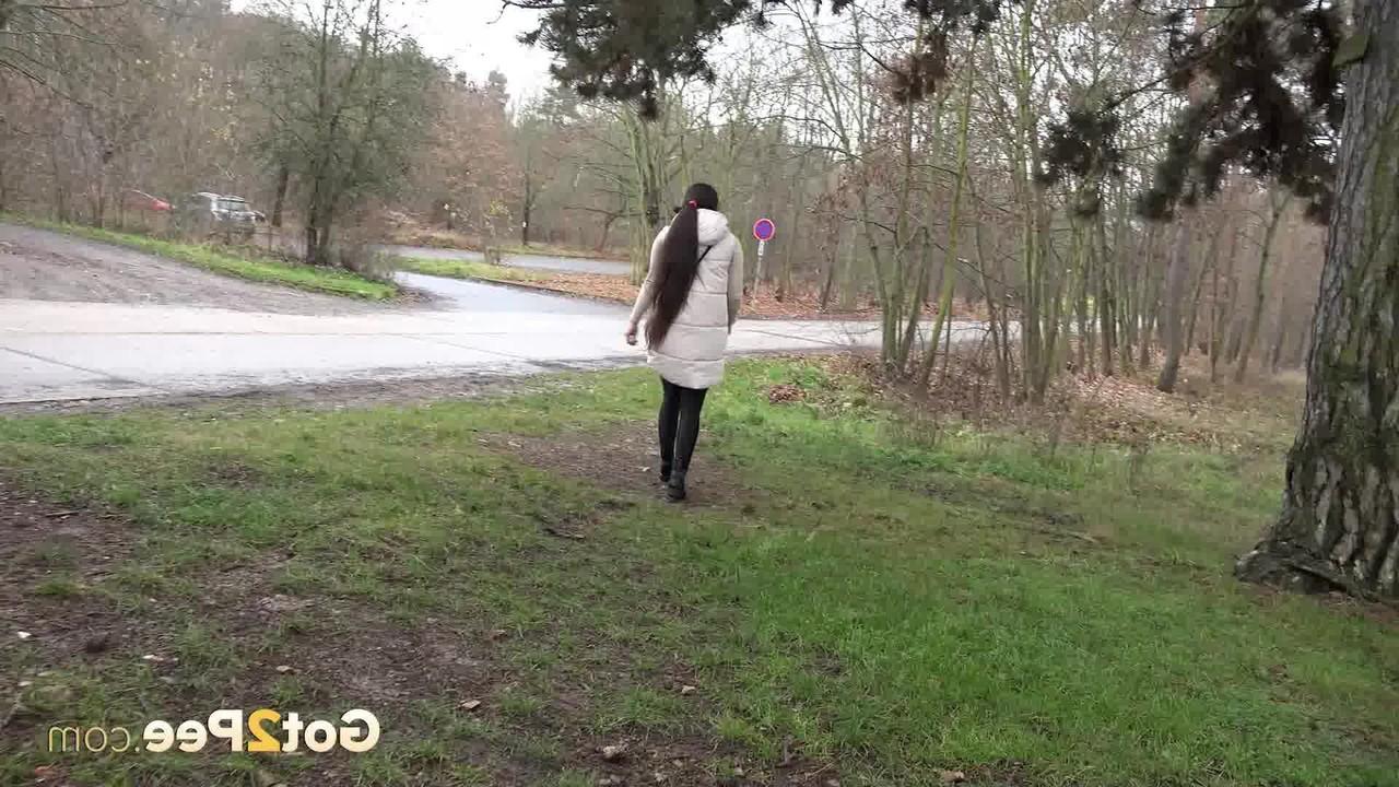 15P Brunette girl Lara Fox squats under a shelter to take a badly needed pee
