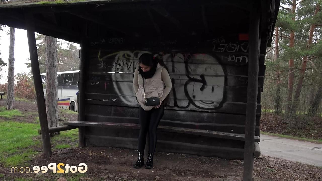 15P Brunette girl Lara Fox squats under a shelter to take a badly needed pee