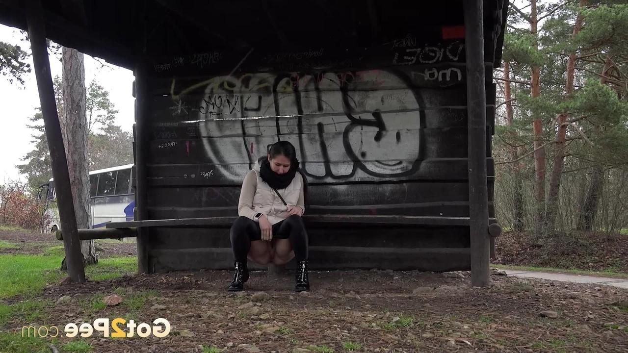 15P Brunette girl Lara Fox squats under a shelter to take a badly needed pee