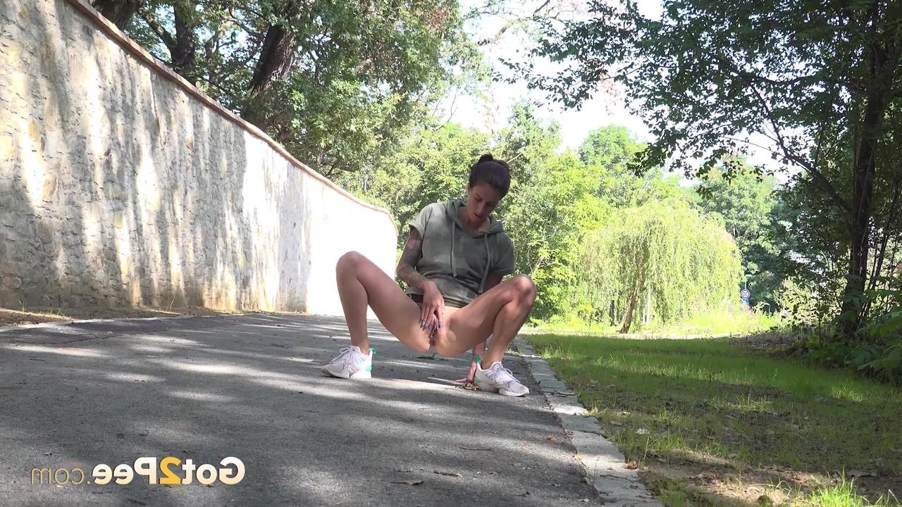 15P La chica sola Ali Bordeaux se levanta la falda para orinar en una carretera pavimentada