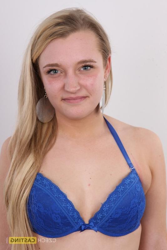 20P Blonde amateur Lucie stands fully clothed before getting entirely naked