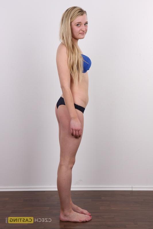 20P Blonde amateur Lucie stands fully clothed before getting entirely naked