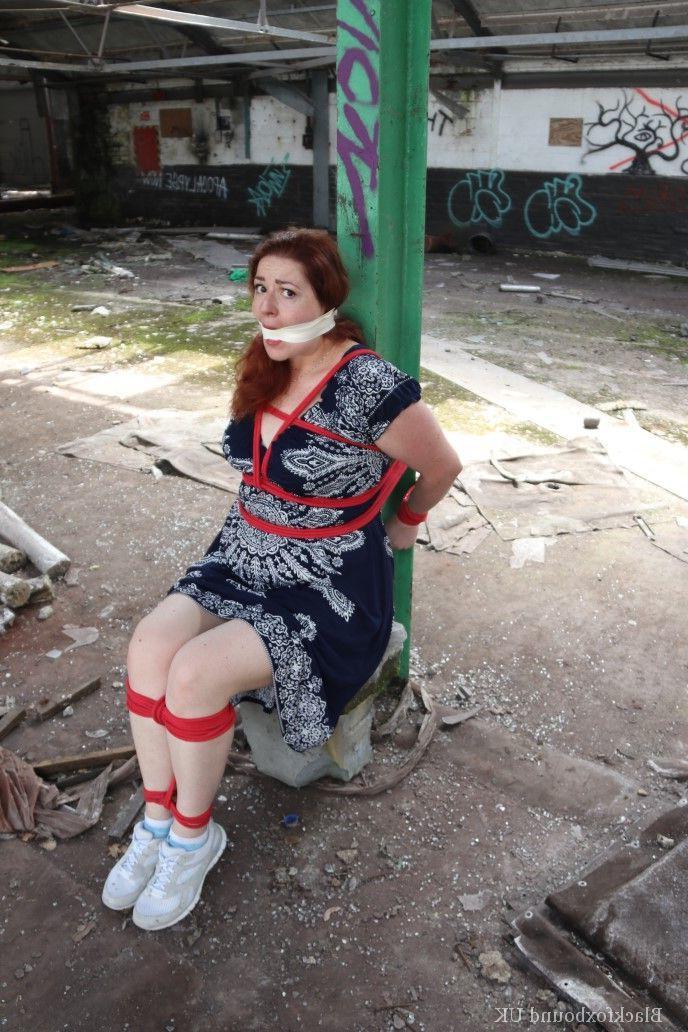 16P Redhead BBW finds herself gagged & tied to a post while clothed in a warehouse