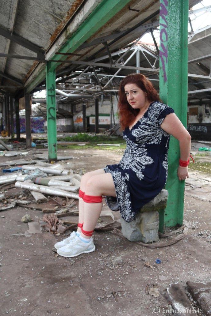 16P Redhead BBW finds herself gagged & tied to a post while clothed in a warehouse