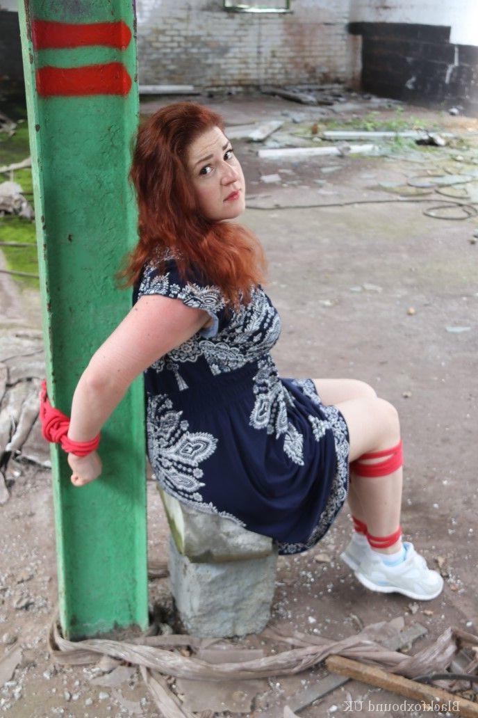 16P Redhead BBW finds herself gagged & tied to a post while clothed in a warehouse