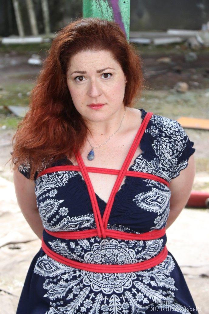 16P Redhead BBW finds herself gagged & tied to a post while clothed in a warehouse
