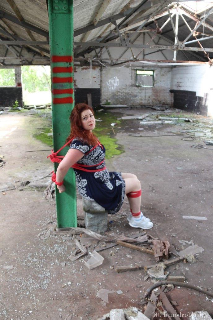 16P Redhead BBW finds herself gagged & tied to a post while clothed in a warehouse
