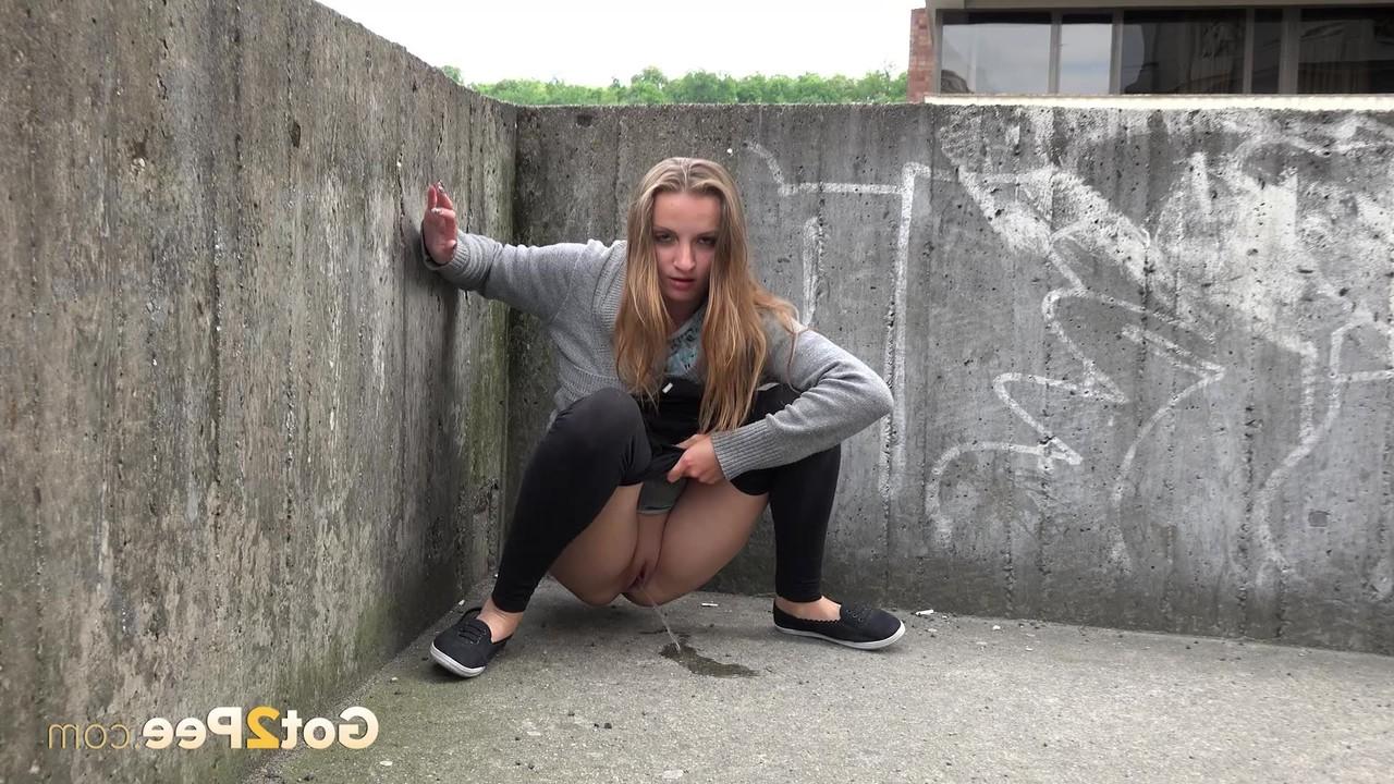 15P A adolescente loira Suzzie expondo os lábios da buceta e a bunda sexy e mijando em público
