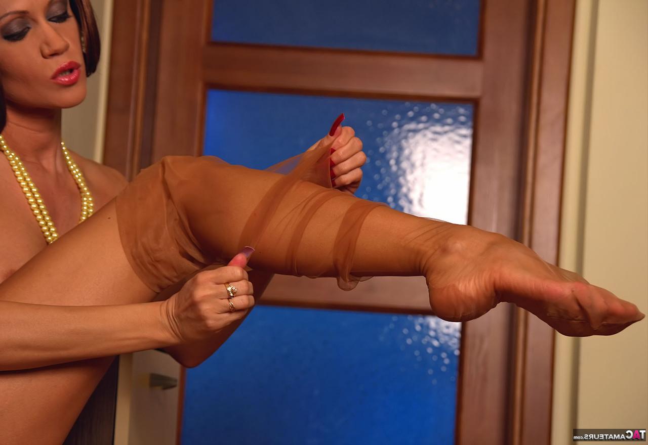 16P Redheaded MILF Eva Diangelo rolls down her nylons while masturbating
