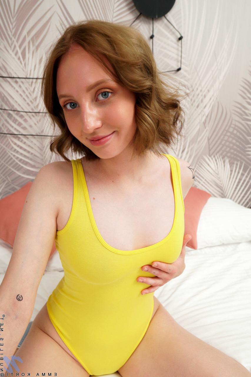 20P La douce jeune Emma Korti montre ses seins naturels et joue avec son manchon rose.