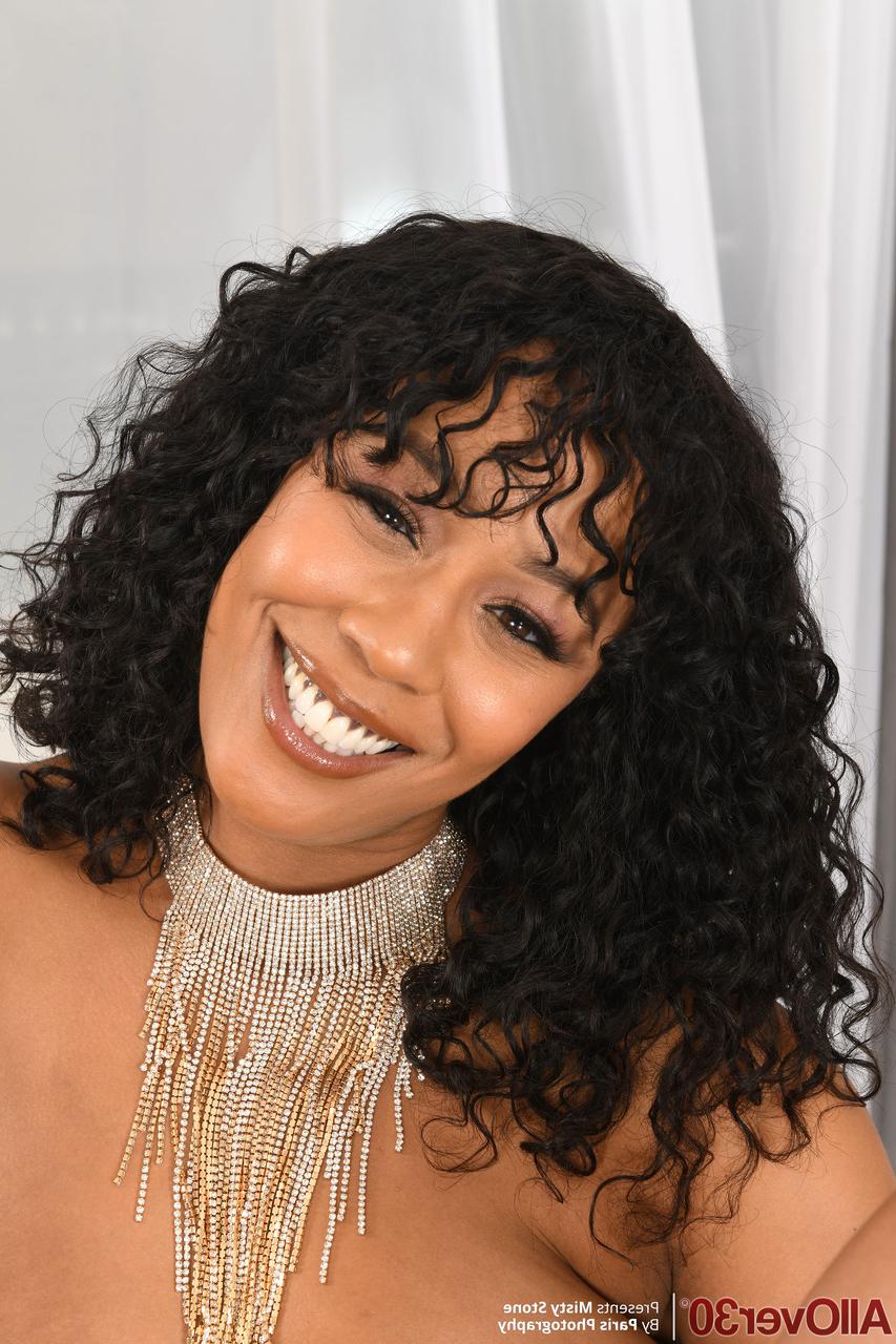 20P Curvy curly haired MILF Misty Stone strips naked & shows off her shaved pussy