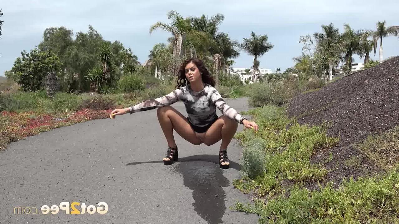 15P A garota gostosa e sexy Lexy se agacha para mijar em uma estrada pavimentada durante o dia
