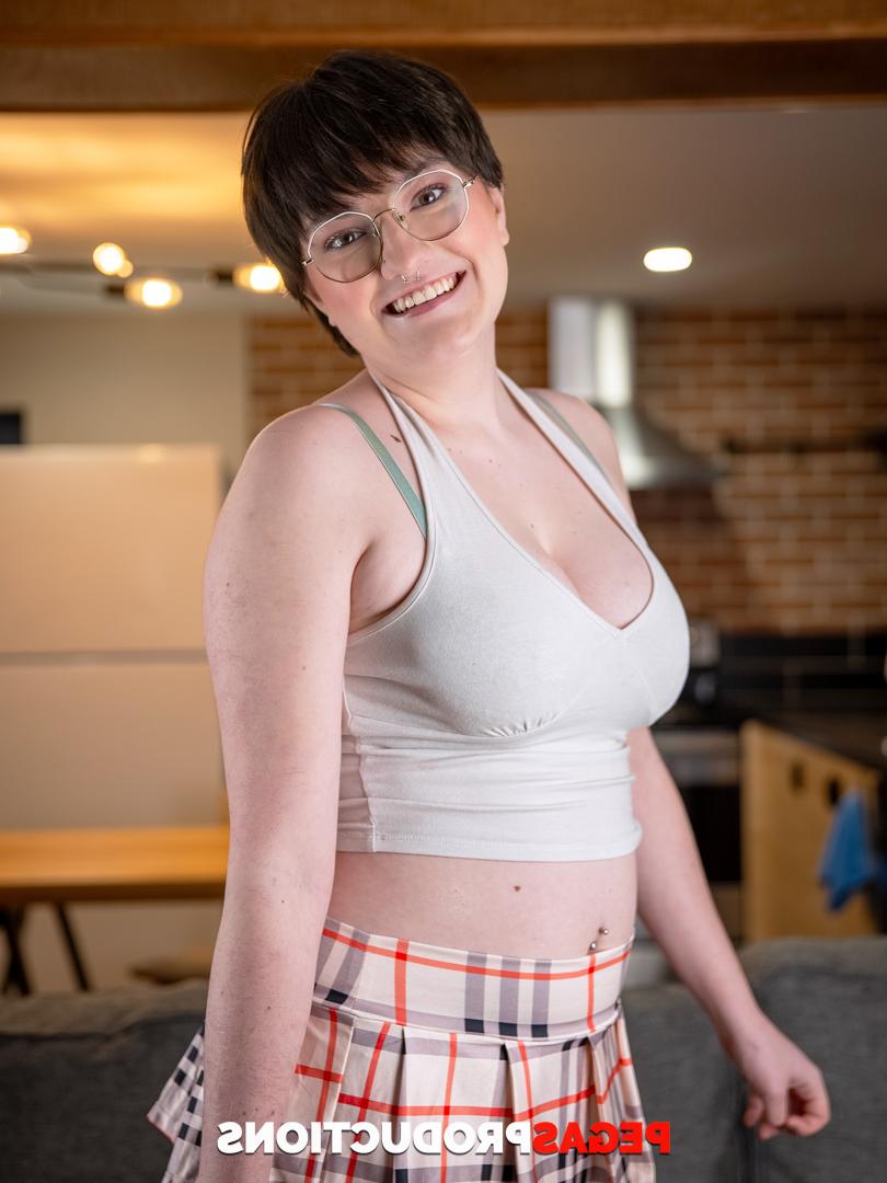 20P Short haired teen in glasses Kitty Kunt displays her big tits and bubble ass