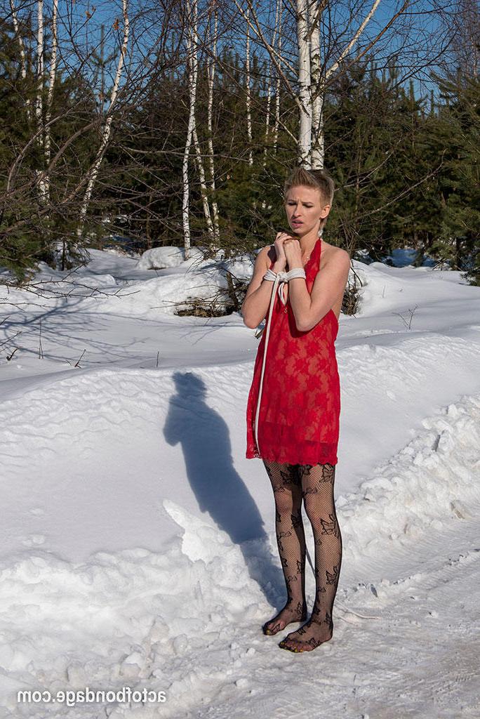 16P Une femelle blanche est tenue debout et obligée de se tenir debout et de s'agenouiller dans la neige.