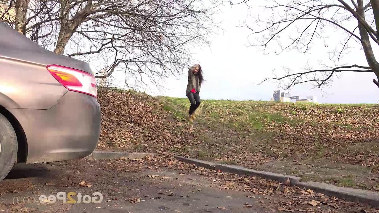 15P A garota caucasiana Esperansa faz xixi urgente atrás de um carro estacionado