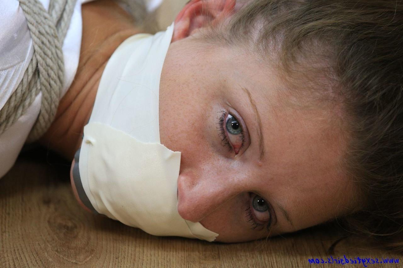 16P Clothed woman is tied up with ropes while silenced with tape over her mouth