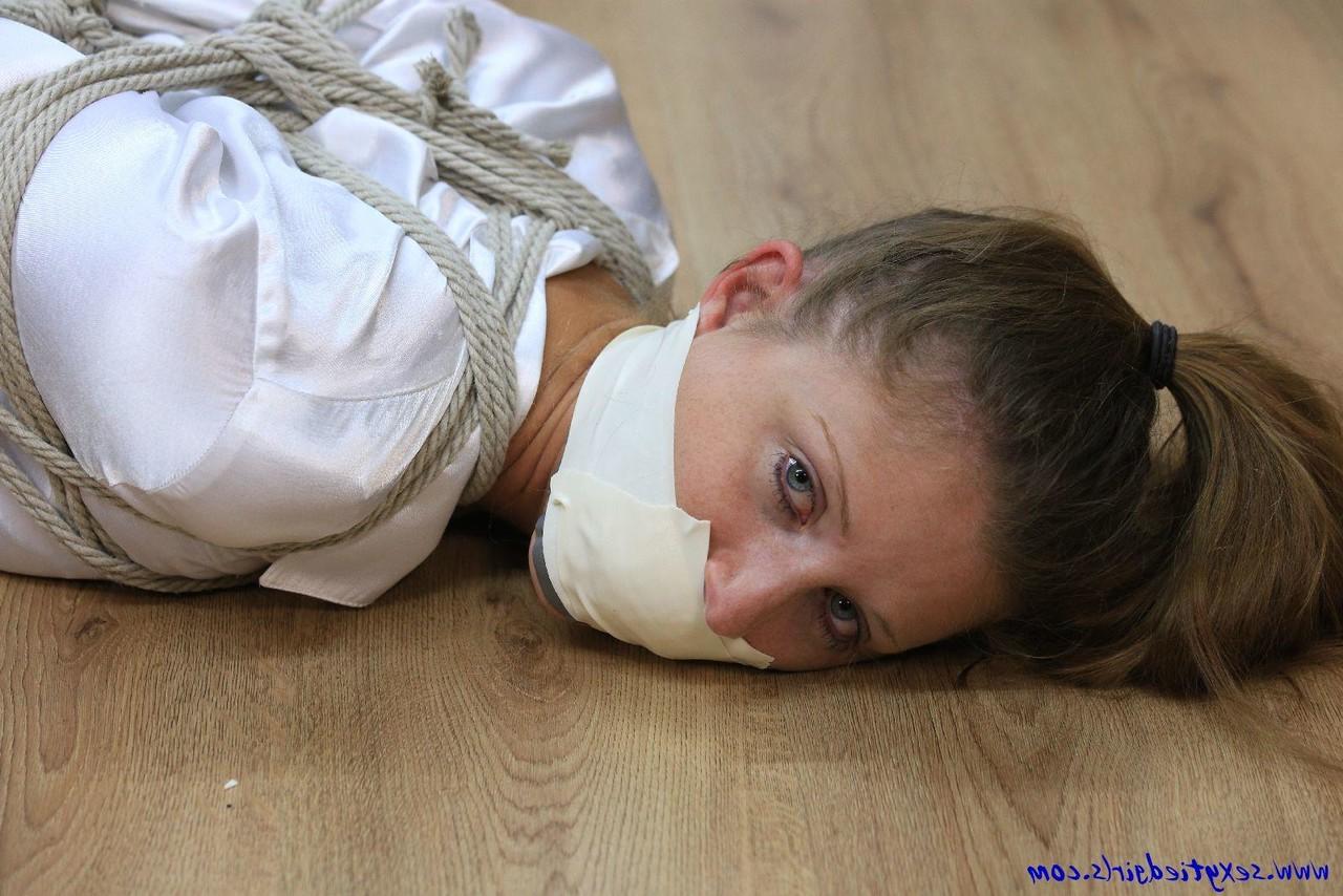16P Clothed woman is tied up with ropes while silenced with tape over her mouth