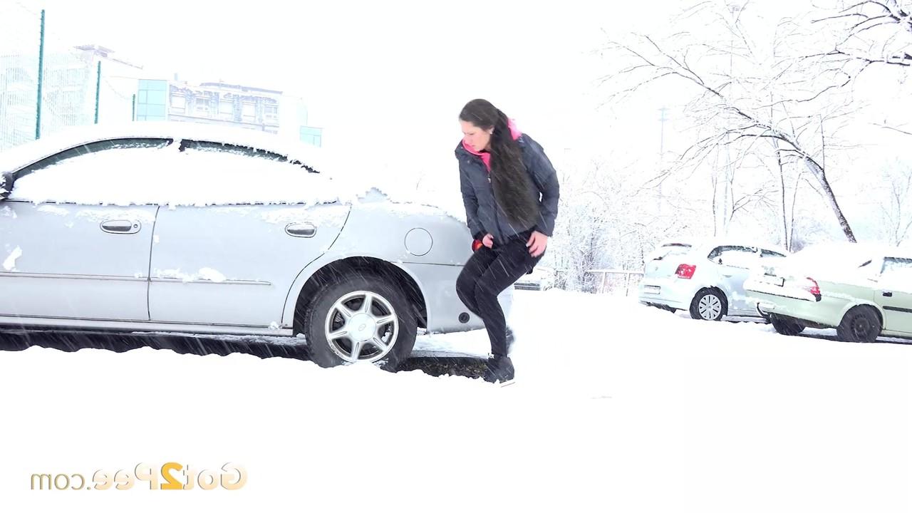 15P Lara Fox mija ao lado de um veículo estacionado durante uma tempestade de neve