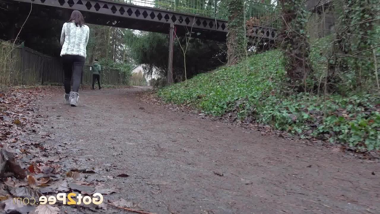 15P A garota branca Victoria Daniels faz xixi ao lado de um caminho com botas de inverno e um casaco