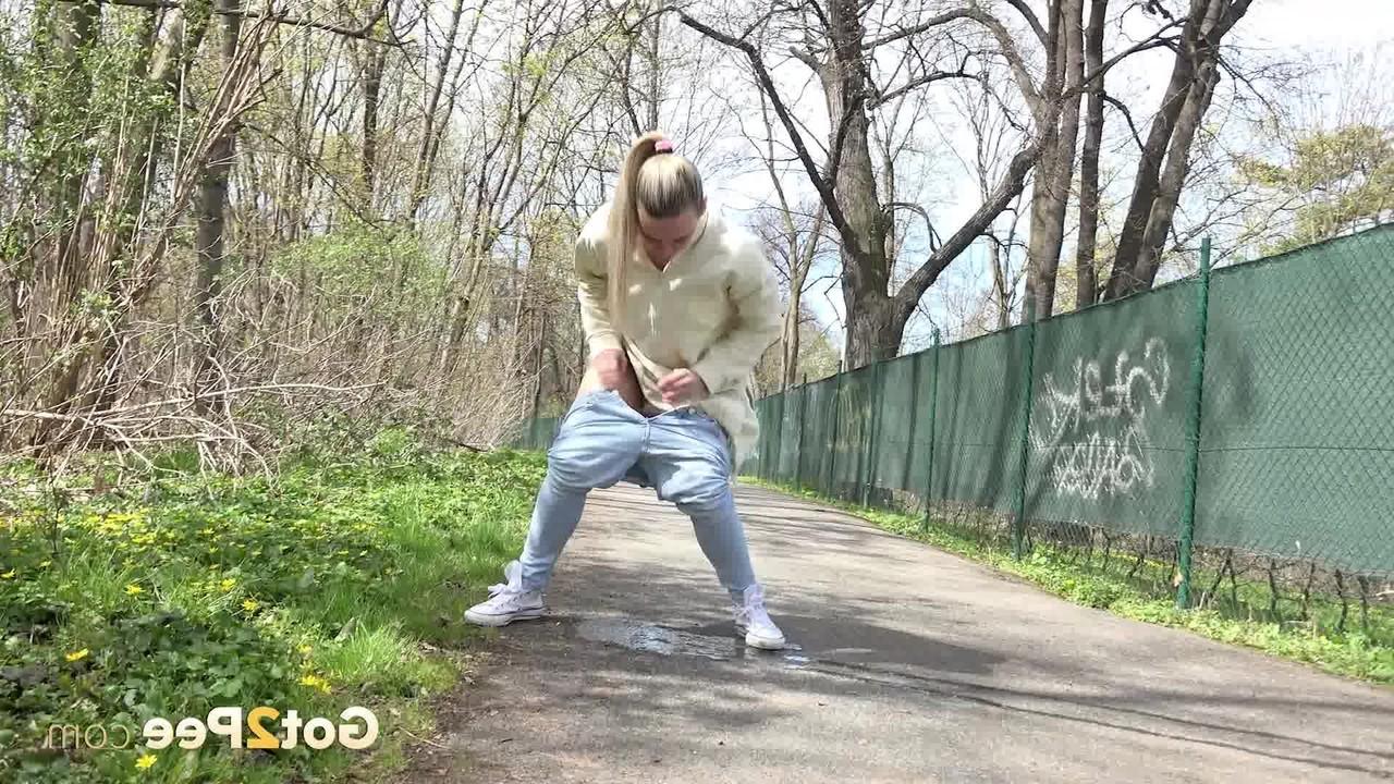15P La rubia Bianca se baja los pantalones deportivos para orinar en un sendero pavimentado